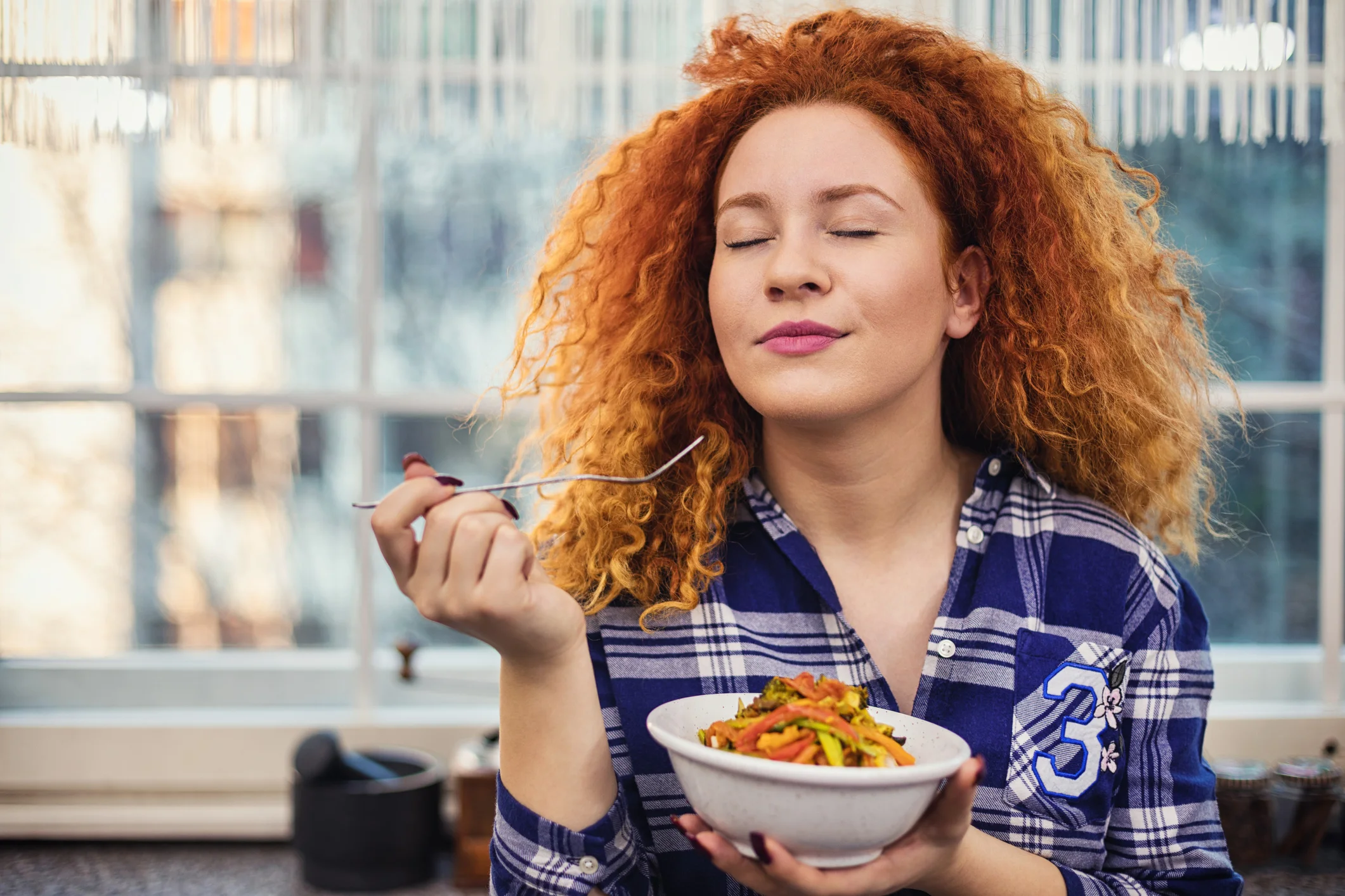 Woman eating bowl of vegetables