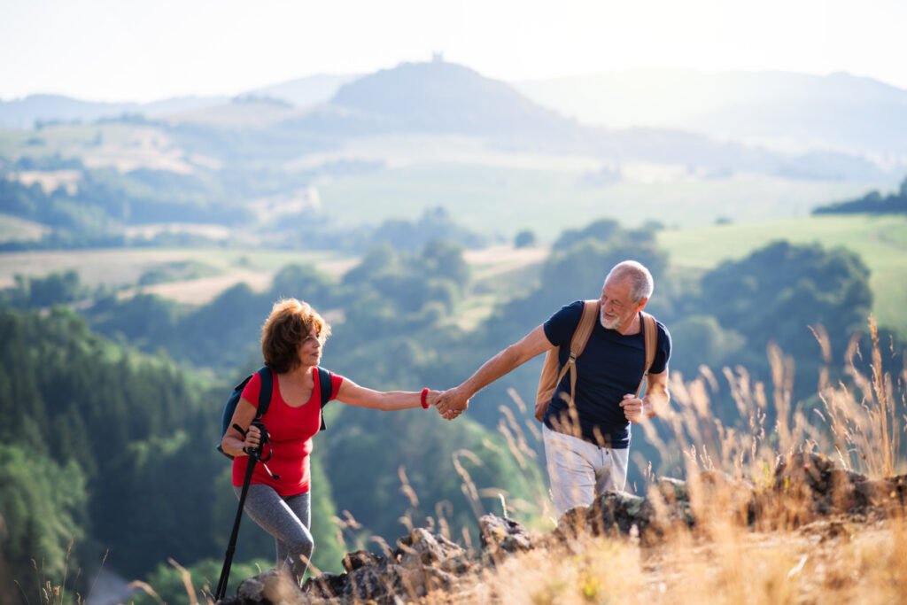 A senior couple traveling and hiking a mountain together